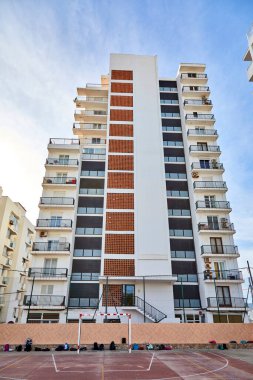 Okul basketbol sahasının önündeki eski binada yerde bir sürü sırt çantası var..