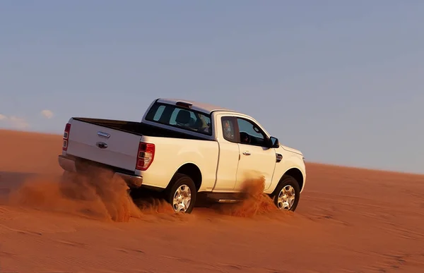 Safári off-road nas areias douradas do deserto em um carro branco — Fotografia de Stock