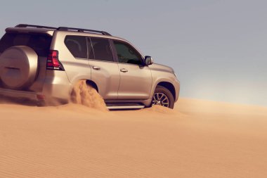 Namib çölünde kumda sıkışmış altın bir arabanın yakınında. Afrika