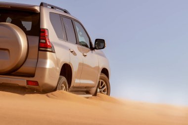 Namib çölünde kumda sıkışmış altın bir arabanın yakınında. Afrika