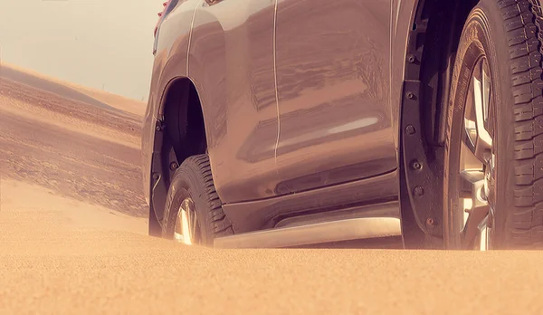 Close up of a golden car stuck in the sand in the Namib desert. Africa