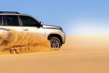 Namib çölünde kumda sıkışmış altın bir arabanın yakınında. Afrika
