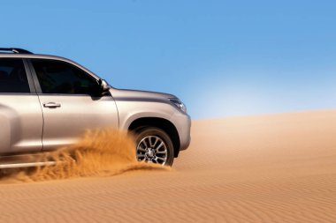 Namib çölünde kumda sıkışmış altın bir arabanın yakınında. Afrika