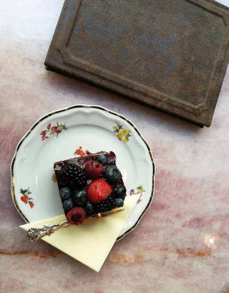 Chocolate cake with berries in a magnificent porcelain dish, in an old European pastry shop