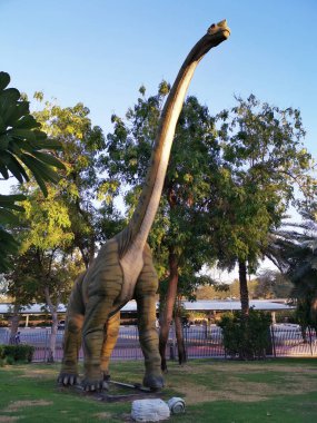 Orijinal büyümedeki bir dinozorun gerçekçi modeli. Dev dinozor heykelleriyle dolu park