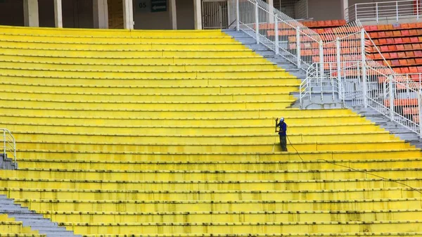 Takarító Munkás Mossa Tömlő Sárga Piszkos Műanyag Ülések Üres Tribünön — Stock Fotó