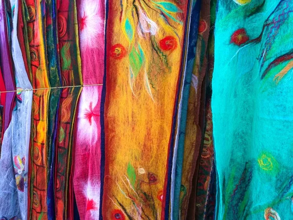 街のお土産屋さんの市場の屋台に吊るされた地元の職人の手作業で作られた美しいカラフルなスカーフの列 グルジアからの最高のプレゼント — ストック写真