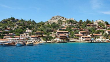 Antalya 'nın Akdeniz kıyısındaki ünlü su altı kenti Kekova' nın yanındaki tepedeki eski kalede limanı ve bulanık arkeolojik alanı olan küçük bir kasabaya panoramik manzara. Mayıs 2019