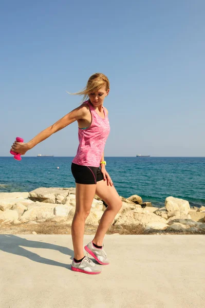 Mujer atlética joven haciendo ejercicio al aire libre: extensiones de tríceps para la fuerza superior del cuerpo — Foto de Stock