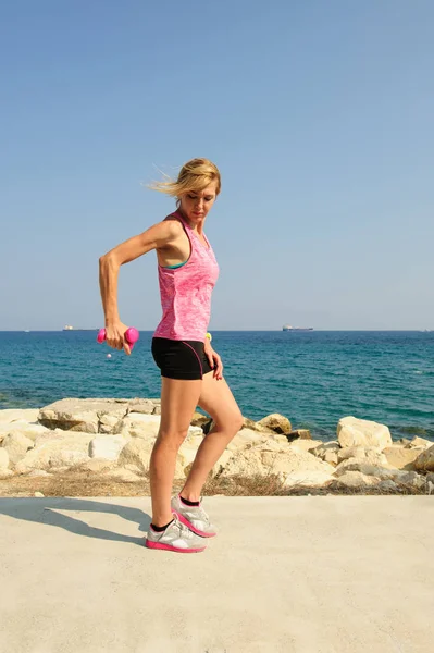 Mujer atlética joven haciendo ejercicio al aire libre: extensiones de tríceps para la fuerza superior del cuerpo — Foto de Stock