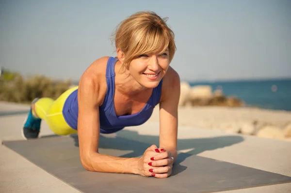 Young athletic woman exercising outdoors: plank for total body strength — Stock Photo, Image