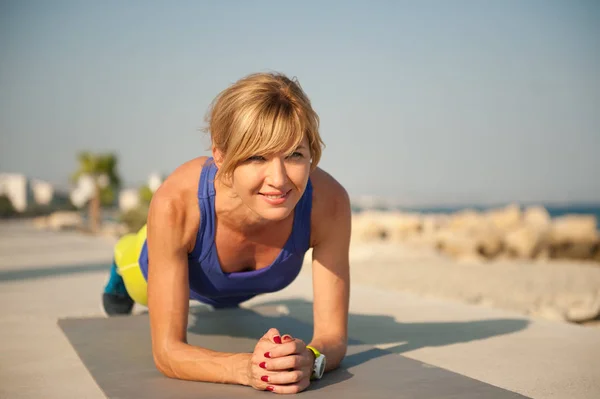 Young athletic woman exercising outdoors: plank for total body strength — Stock Photo, Image