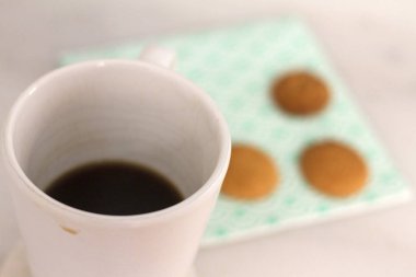 Günlük sahne: nötr arka plan üzerinde kahve ve tereyağı kurabiye