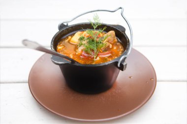 Hafif ahşap zemin üzerinde izole edilmiş çorbalı kazan.