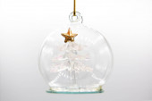 Křišťálová hračka s průhledným vánoční stromeček uvnitř se zlatou hvězdou izolované na bílém pozadí.