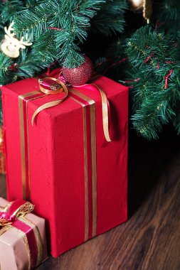 Noel ağacının yanında parlak bir topu olan güzel bir Noel hediyesi kutusu..