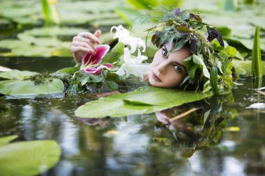 beautiful sexy woman in a wreath of flowers bathes in a lake with water lilies clipart