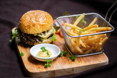 Ev yapımı hamburger, patates kızartması, marul ve peynir.