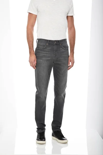 Moda slim fit gris hombres denim emparejado a lo largo de zapatillas negras con fondo blanco —  Fotos de Stock