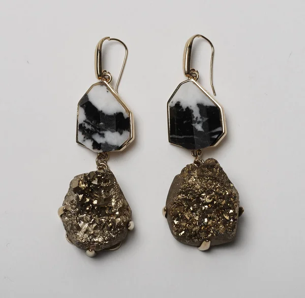 Elegant loop earrings with black marble and golden stone at bottom with white background