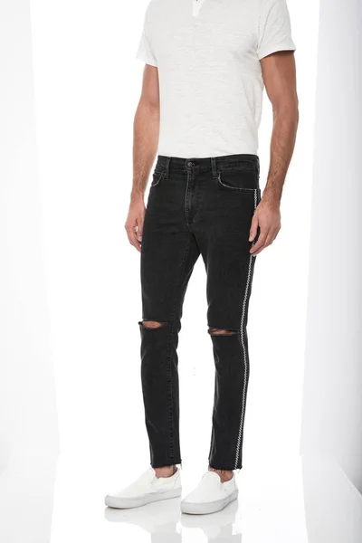 Camiseta clásica para hombre blanca con pantalón a rayas en la rodilla emparejado con zapatillas negras con fondo blanco —  Fotos de Stock