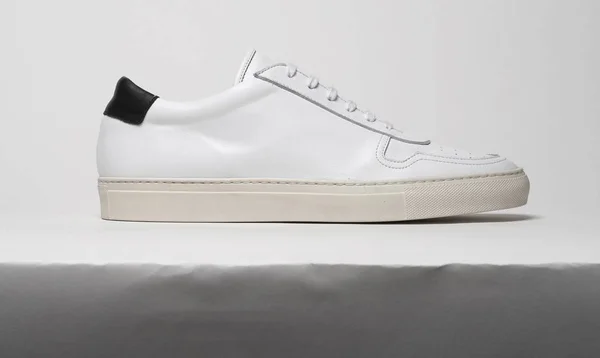 Branco tênis casuais com base branca e fundo branco — Fotografia de Stock