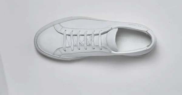 Случайные белые кроссовки для мужчин с белым основанием на белом фоне — стоковое фото