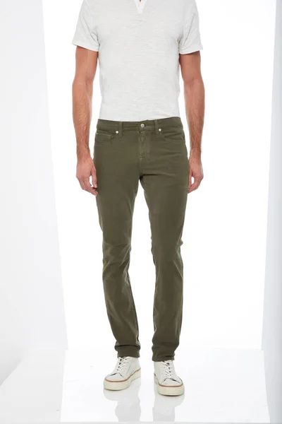 Pantalone verde militare slim fit abbinato a t-shirt bianca e sneakers bianche con sfondo bianco — Foto Stock