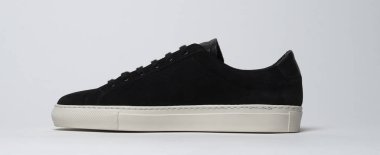 Siyah ve beyaz arka planlı siyah spor ayakkabılar.