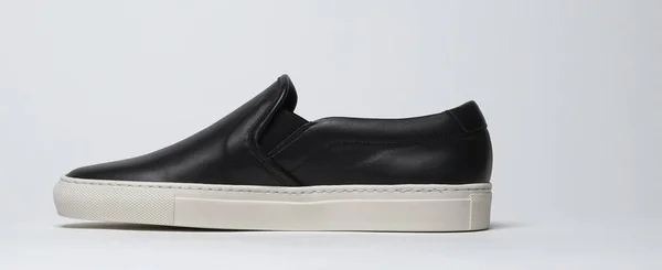 Black loafers with white base and white background