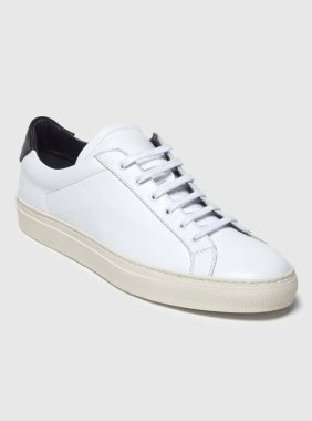 Beyaz zemin ve beyaz arka planda beyaz spor ayakkabılar, beyaz arka planda sade beyaz spor ayakkabılar.