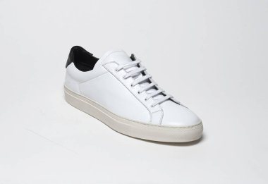 Beyaz zemin ve beyaz arka planda beyaz spor ayakkabılar, beyaz arka planda sade beyaz spor ayakkabılar.