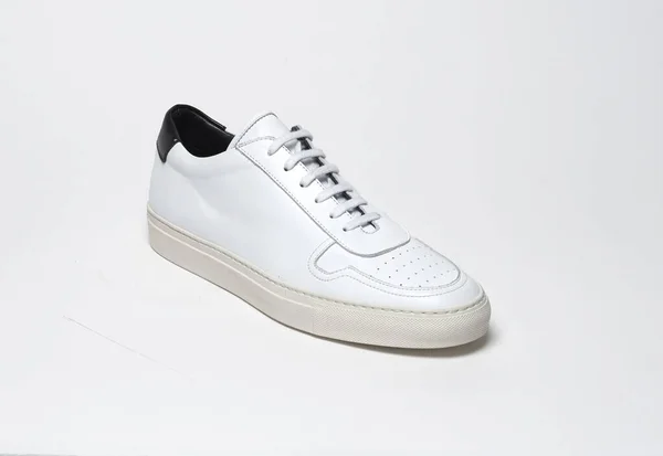Beyaz zemin ve beyaz arka planda beyaz spor ayakkabılar, beyaz arka planda sade beyaz spor ayakkabılar. — Stok fotoğraf