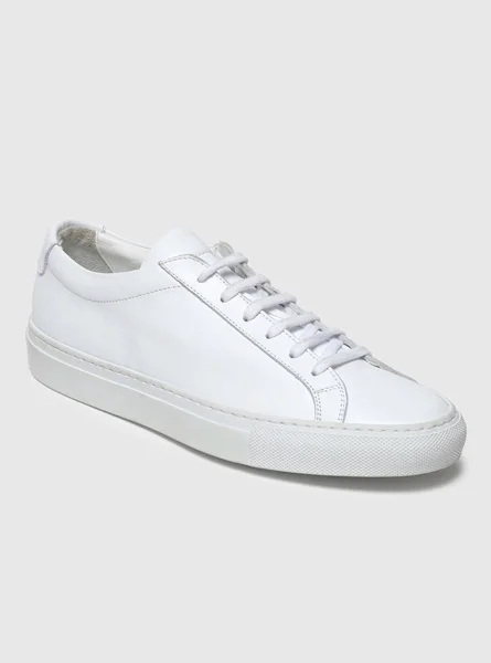 Beyaz zemin ve beyaz arka planda beyaz spor ayakkabılar, beyaz arka planda sade beyaz spor ayakkabılar. — Stok fotoğraf