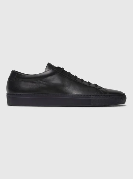 Siyah ve beyaz arka planlı siyah spor ayakkabılar. — Stok fotoğraf