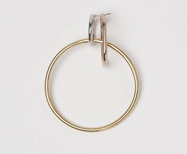 Beyaz arka planı olan kadınlar için altın halka küpeler.