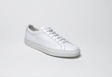 Beyaz zemin ve beyaz arka planda beyaz spor ayakkabılar, beyaz arka planda sade beyaz spor ayakkabılar.