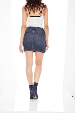 Mavi kot, beyaz atlet ve siyah arka planlı siyah ayakkabıyla eşleştirilmiş kadınlar için yırtık şort