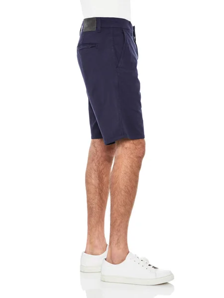 흰색 바탕에 파란색 데님 반바지와 흰색 운동화를 착용 한 평범 한 흰색 티셔츠와 흰색 배경 신발을 신고 있는 남성용 평상복 바지를 입고 있다. — 스톡 사진
