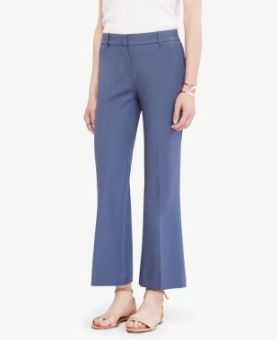 Beyaz kollu tişört ve beyaz arka planda düz ayakkabı giyen kadınlar için mavi resmi pantolon