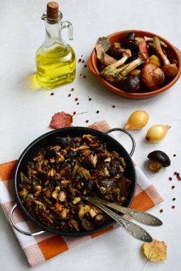 Kareli peçete, soğan, ayçiçeği yağı ve hafif arkaplanda biberli mantarlı tava.