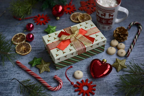 선물 상자, 눈송이, 크리스마스 공, 마시멜로가 들어 있는 머그잔, 파란 배경에 롤리팝 과 전나무 가지로 이루어진 크리스마스 구성 물. — 스톡 사진