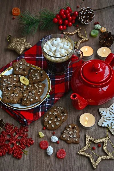 Mug with coffee and marshmallows, homemade cookies, red teapot, snowflakes, nuts, napkin in a composition of bright winter still life — Stock Photo, Image