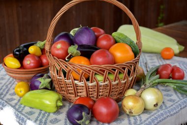 Taze domatesli hasır sepet, patlıcan, salatalık, biber, kabak, peçetede soğan