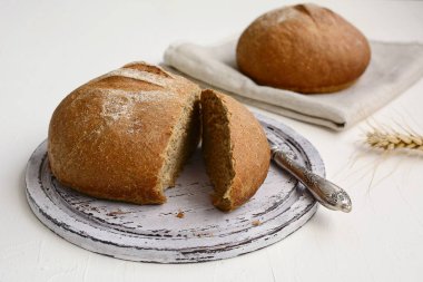 Tahta kesme tahtasında dilimlenmiş çavdar ekmeği ve peçetede çavdar ekmeği. Kırsal hayat. Doğal ışık.