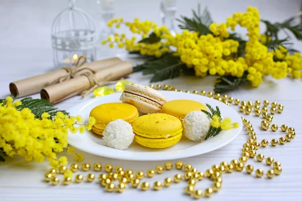 Kokosové Sušenky Žluté Makaróny Bílém Talíři Mimosové Větve Řemeslné Závitky — Stock fotografie