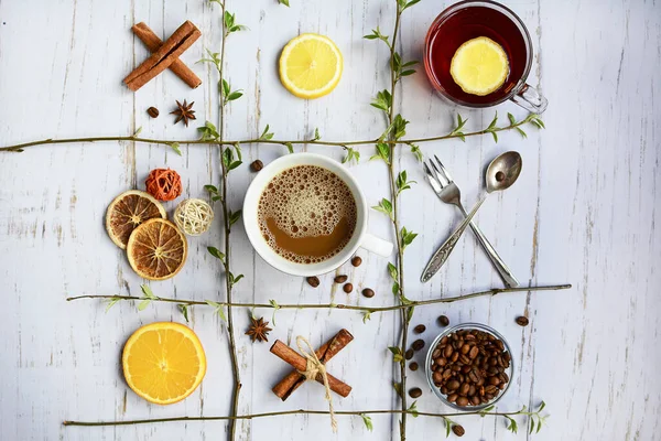 紅茶とコーヒーのカップ レモンとオレンジの円 シナモンスティック スプーンと軽い木製の背景にフォーク ゲームIc Tac Tooth トップ表示 — ストック写真