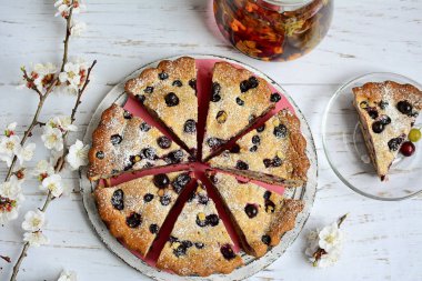 Frenk üzümlü ev yapımı turta ve krema şekeri çaydanlıkta bitki çayı ve tabakta bir parça kek. Yukarıdan bak. Evde rahatla