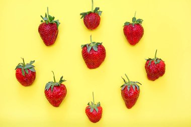 Parlak sarı arka planda çilek. Yukarıdan görüntüle