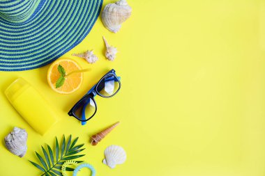 Denizde dinlenmek için yazlık eşyalar, deniz kabukları, parlak sarı arka planda meyveler. Yaz tatili kavramı. Tasarım ve metin için boşluk.